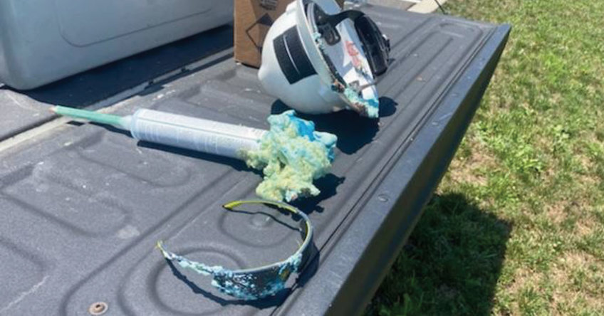 Bed of a truck showing the exploded end of a foam conduit alongside a pair of VS250 safety glasses.
