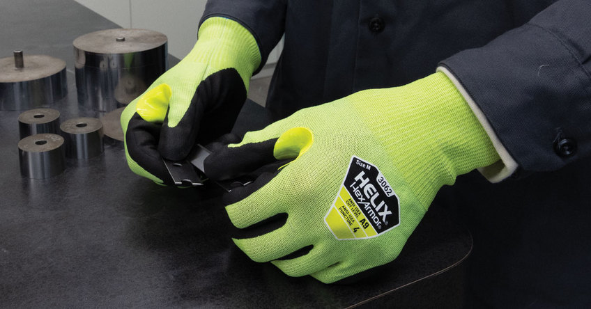 Hands wearing the Helix 3062 high dexterity work gloves handing razor blades.